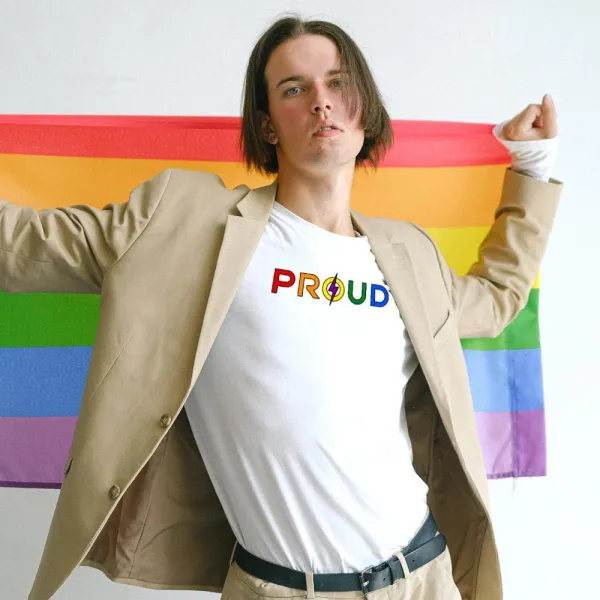 Man wears white t shirt with proud across the front in rainbow colours